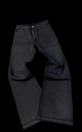 Black jeans on a white surface with a blurred background