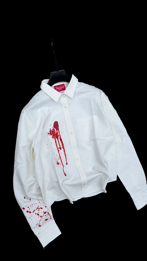 White jacket with red blood-like stains on a gravel surface
