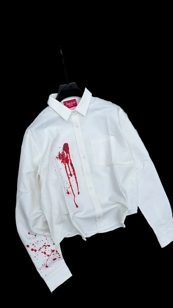 White jacket with red blood-like stains on a gravel surface