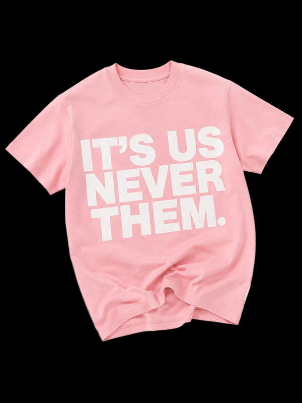 Pink t-shirt with white text 'IT'S US NEVER THEM' on a white background
