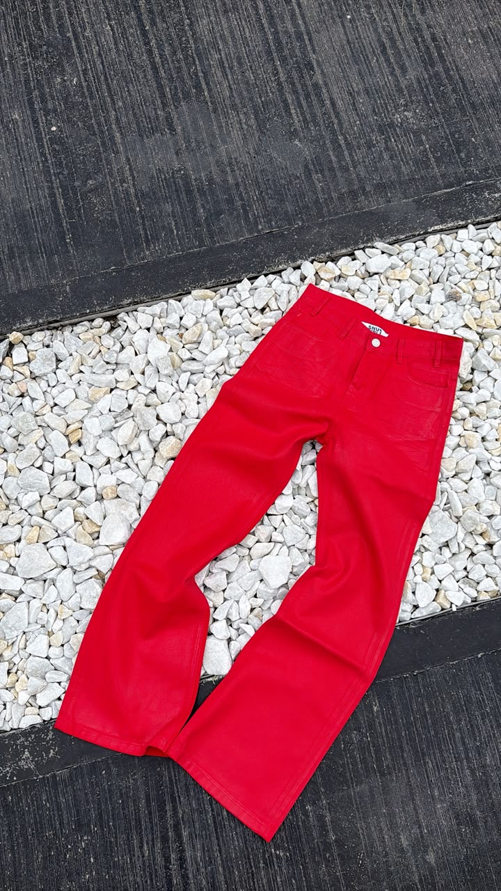 Red pants on a pebbled surface with a black mat underneath