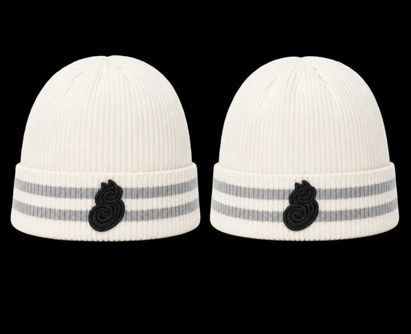 Two white knit hats with black and gray accents on a white background